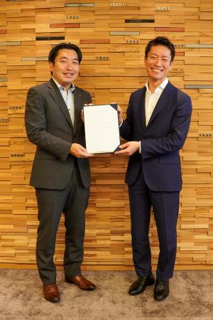 笑顔で引き継ぎ書を持つ新旧副市長