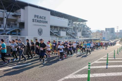 ピーススタジアムの前の道路を走るランナー