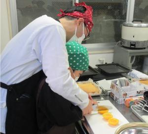 親が果物切りを手伝っている